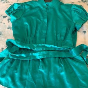 A teal blouse with a matching belt.